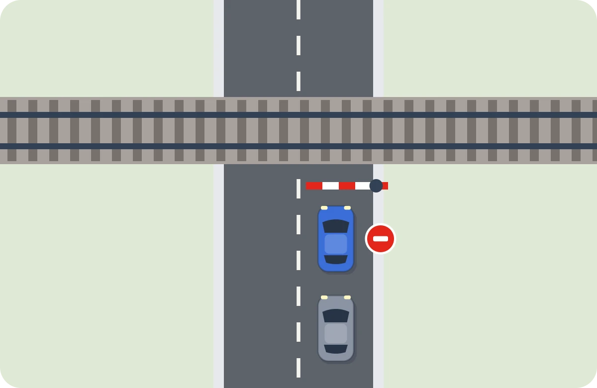 Paso a nivel cerrado. Barrera bajada o moviéndose: no se entra. Se espera en el carril, uno detrás de otro.